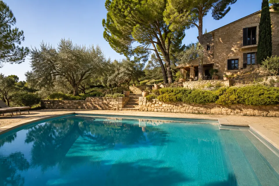 Pool beside a stone terrace and Mediterranean planting